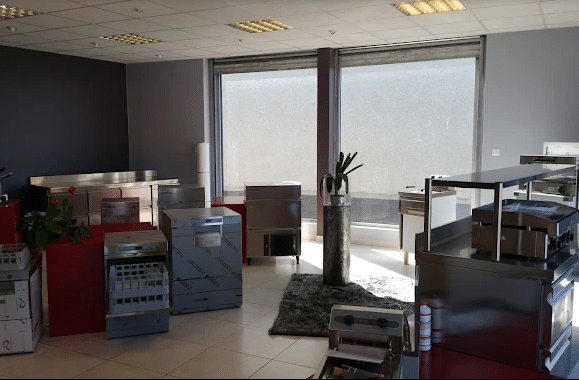 Showroom lumineux présentant divers équipements de cuisine professionnelle en acier inoxydable, incluant des machines à glaçons et des plaques de cuisson.