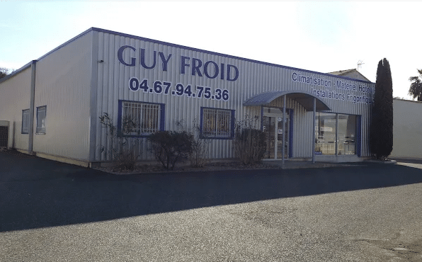 Entrepôt de Guy Froid, spécialisé en Climatisation et Installations Frigorifiques. Numéro : 04.67.94.75.36. Façade métallique grise.